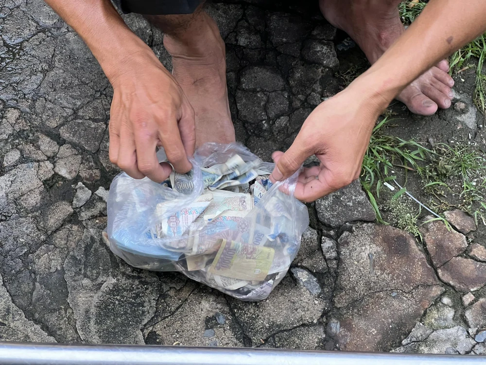 Tiền chẵn, tiền lẻ được người này bỏ gọn trong túi ni lông.