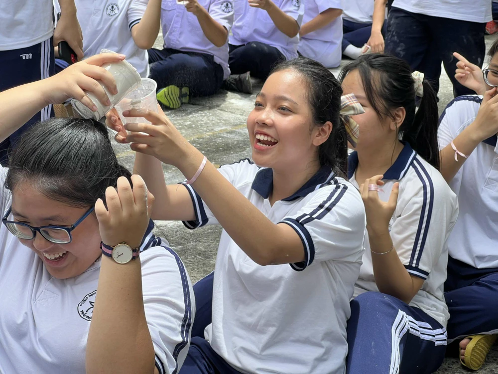 Học sinh tham gia trò chơi "Chuyền bột bằng ly", tạo không khí hấp dẫn.