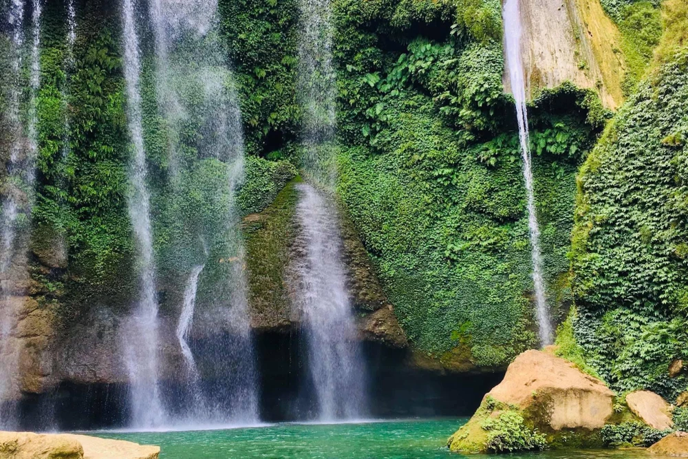 Thác được bao quanh bởi cây cối xanh tươi. Ảnh : PHƯƠNG MAI