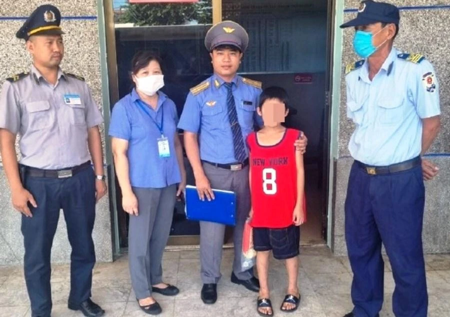 Các nhân viên ngành đường sắt hỗ trợ bé trai trở về quê. Ảnh: H.H