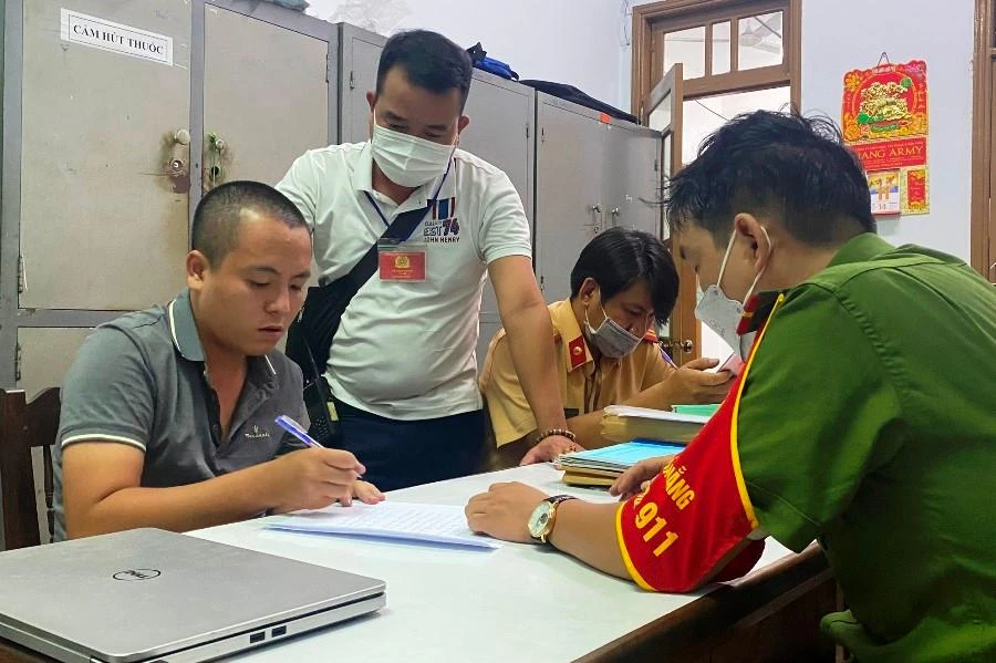 Nghi phạm Lưu Thành Long (bìa trái) tại cơ quan công an. Ảnh: H.H