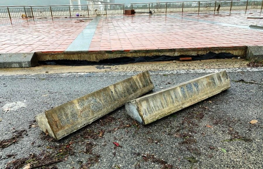 Những mảng đá to ốp vào vỉa hè bị sóng đánh bong tróc. Ảnh: HẢI HIẾU
