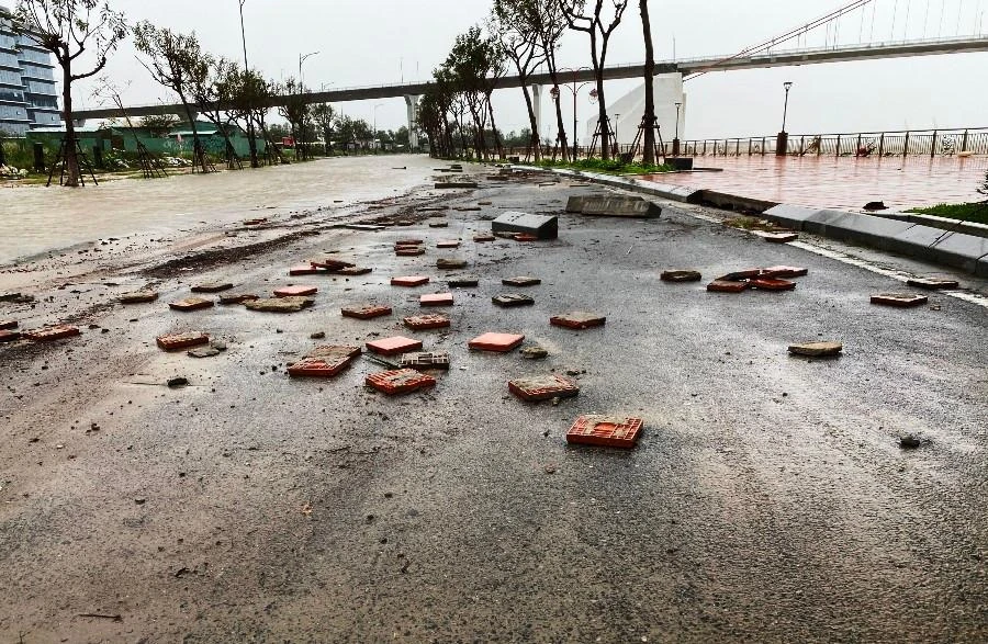 Gạch đá trên vỉa hè bị sóng đánh bong tróc xuống mặt đường. Ảnh: HẢI HIẾU