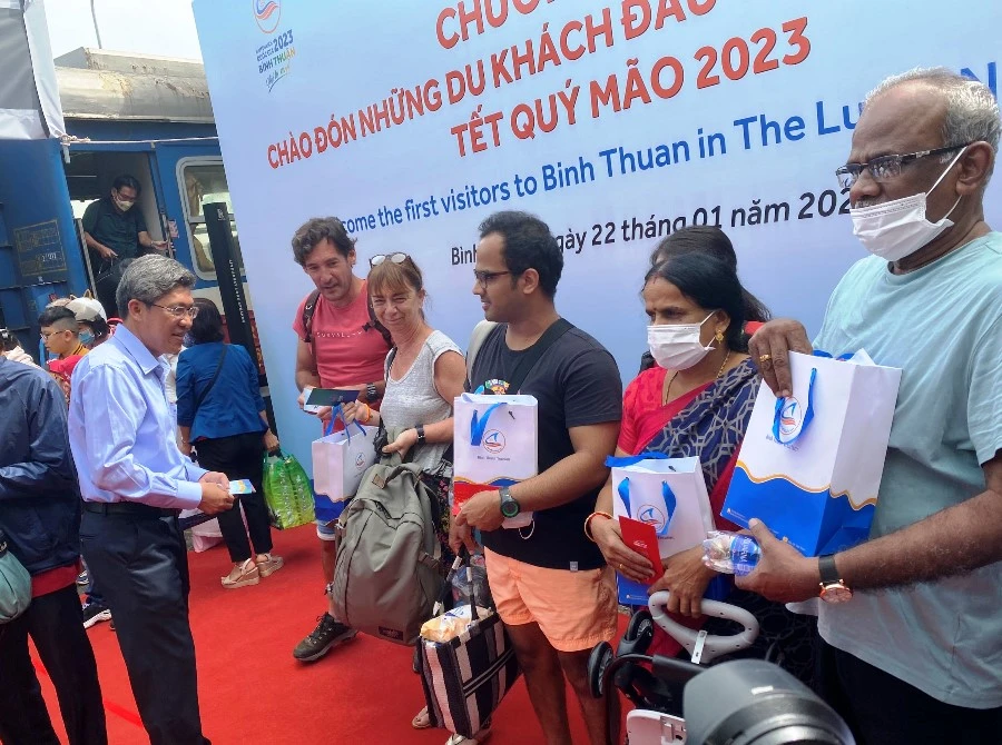 Lãnh đạo tỉnh Bình Thuận lì xì và tặng quà lưu niệm cho du khách ngày mùng một tết. Ảnh: HẢI HIẾU