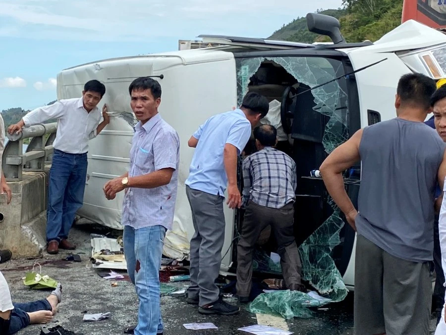 Mọi người nỗ lực cứu nạn nhân mắc kẹt trong xe 16 chỗ. Ảnh: H.H