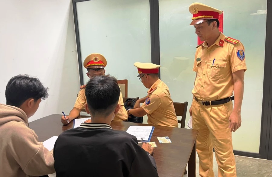 CSGT lập biên bản đối với hai thanh niên vi phạm. Ảnh: H.H