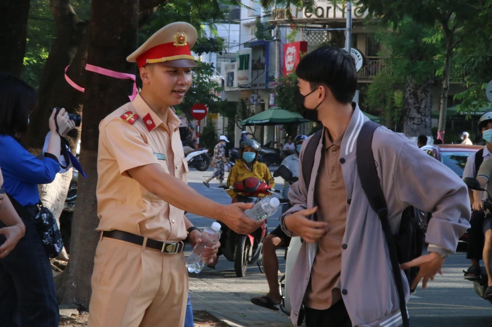 Lực lượng CSGT hỗ trợ phát nước cho các thí sinh. Ảnh: HẢI HIẾU