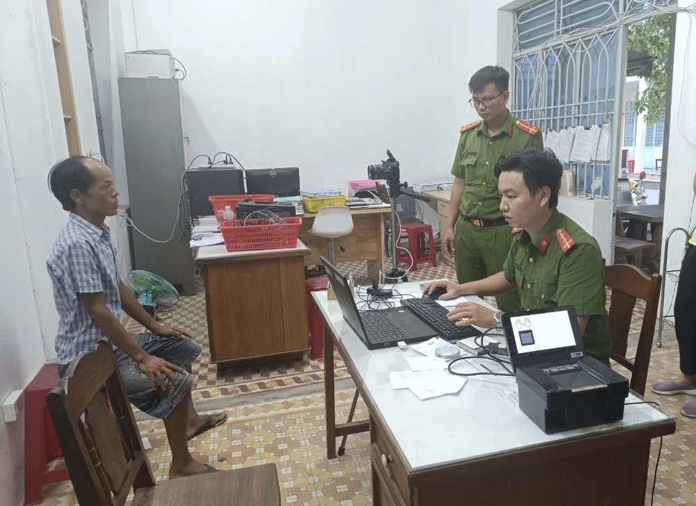 Cán bộ công an đang làm thủ tục để anh Châu được cấp CCCD. Ảnh: H.H