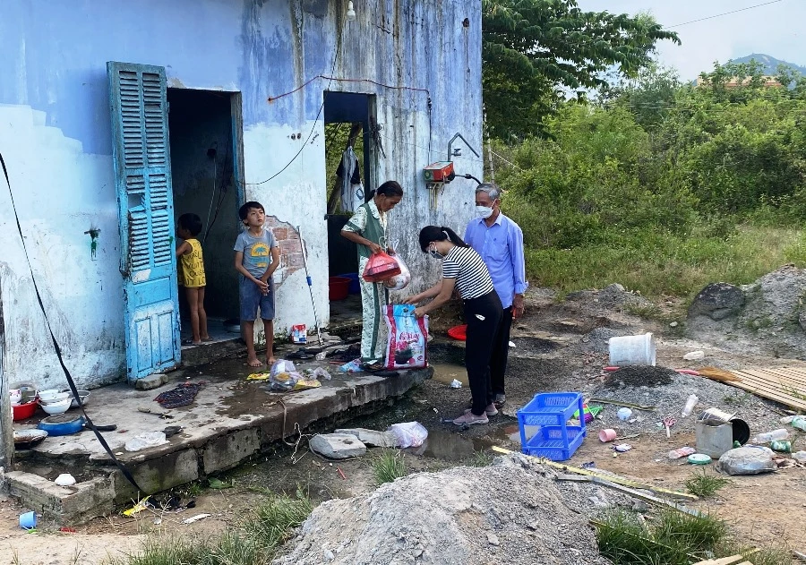 Đại diện nhóm thiện nghiện trao quà là nhu yếu phẩm cho gia đình. Ảnh: HẢI HIẾU