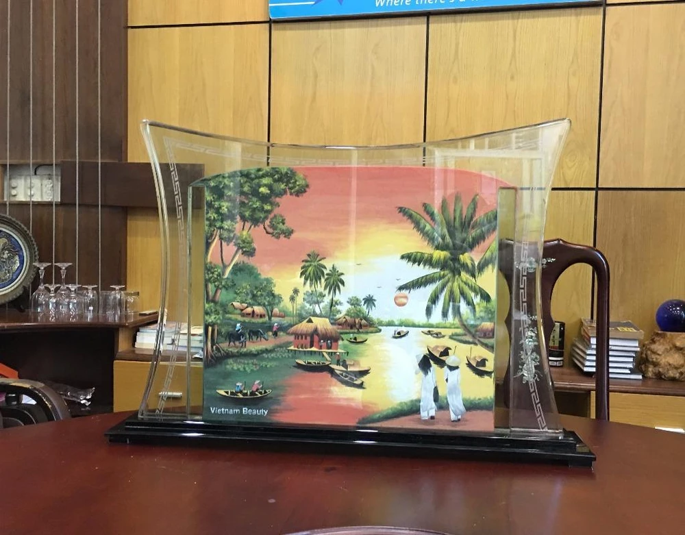 Cảnh làng quê Việt Nam thanh bình phía sau bức tranh.