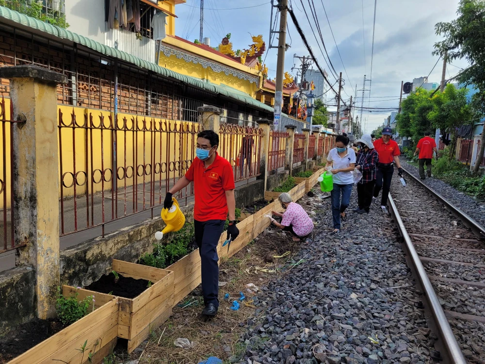 Người dân trồng cây tại tuyến đường sắt Mai Văn Ngọc (đoạn từ Nguyễn Văn Trỗi đến Trần Hữu Trang).