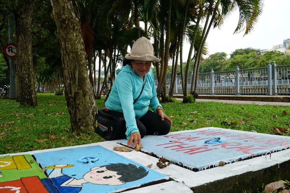 "Tôi làm nghề bán vé số, tôi hay bán ở khu vực này nè. Cỡ 1 tháng trước tôi đi ngang thấy người vẽ nên lại xem, tranh vẽ rất đẹp mà lại ý nghĩa nữa. Nhiều khi thấy có rác hay lá trên tranh là tôi gom bỏ thùng rác vì nó làm xấu bức tranh, xấu nơi công cộng." - bà Phan Thị Kim Liên, ngụ quận Bình Thạnh, TP.HCM chia sẻ.