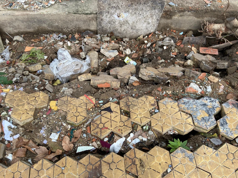 Đất lở khiến gạch lót vỉa hè rơi xuống. Ảnh HUỲNH THƠ