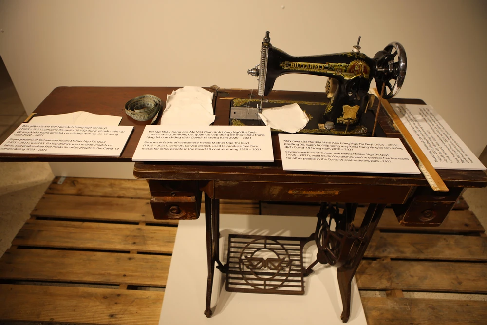 Máy may, thước dây, thước gỗ, rập giấy, vải ráp khẩu trang của Mẹ Việt Nam Anh hùng Ngô Thị Quýt (1925 – 2021), phường 5, quận Gò Vấp dùng may khẩu trang tặng bà con chống dịch COVID-19 trong năm 2020 – 2021.