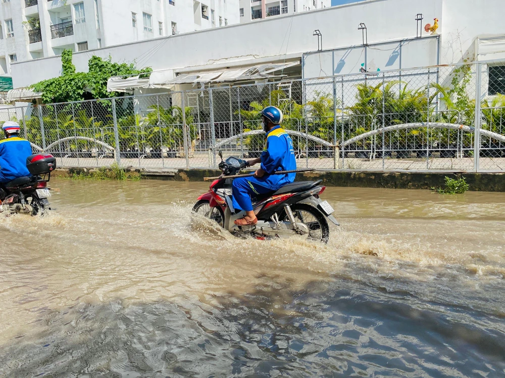 Nước ngập đến nửa bánh xe. Ảnh: HUỲNH THƠ