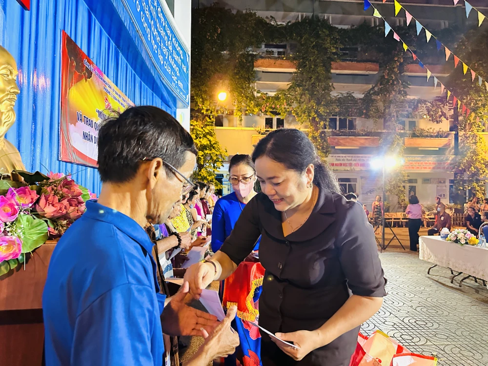 Bà Trần Thị Diệu Hiền, Chủ tịch UBND phường 11, quận Phú Nhuận, TP.HCM trao quà cho các hộ dân. Ảnh: HUỲNH THƠ