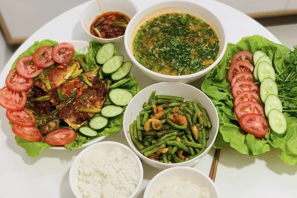 Chị Tina Nguyễn cùng chồng vào bếp để tham gia cuộc thi (Cá bạc má sốt cà, canh cà chua trứng, đậu que xào tóp mỡ). Ảnh: NVCC