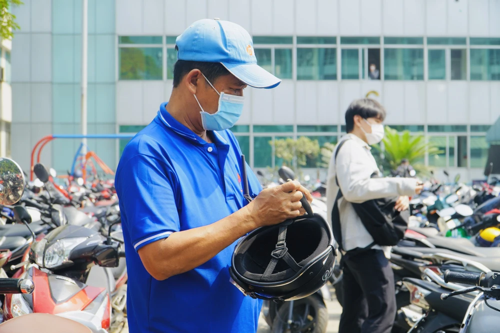 Để không làm ướt đồ trên xe, sinh viên được nhà trường nhắc nhở úp mũ bảo hiểm trước khi rời đi. Ngoài ra, nhân viên nhà trường cũng kiểm tra một lượt trước khi phun. Ảnh: HT
