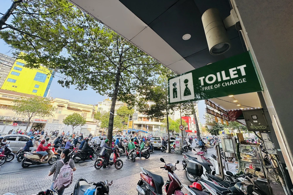 Trao đổi với phóng viên, một số người đi đường cho biết việc gắn bảng trước cửa hàng như thế sẽ giúp người dân dễ dàng thấy được các địa điểm cho dùng nhà vệ sinh công cộng. Ảnh: HUỲNH THƠ