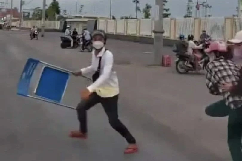 Người thanh niên cầm ghế sắt chặn xe cứu thương. Ảnh: MXH