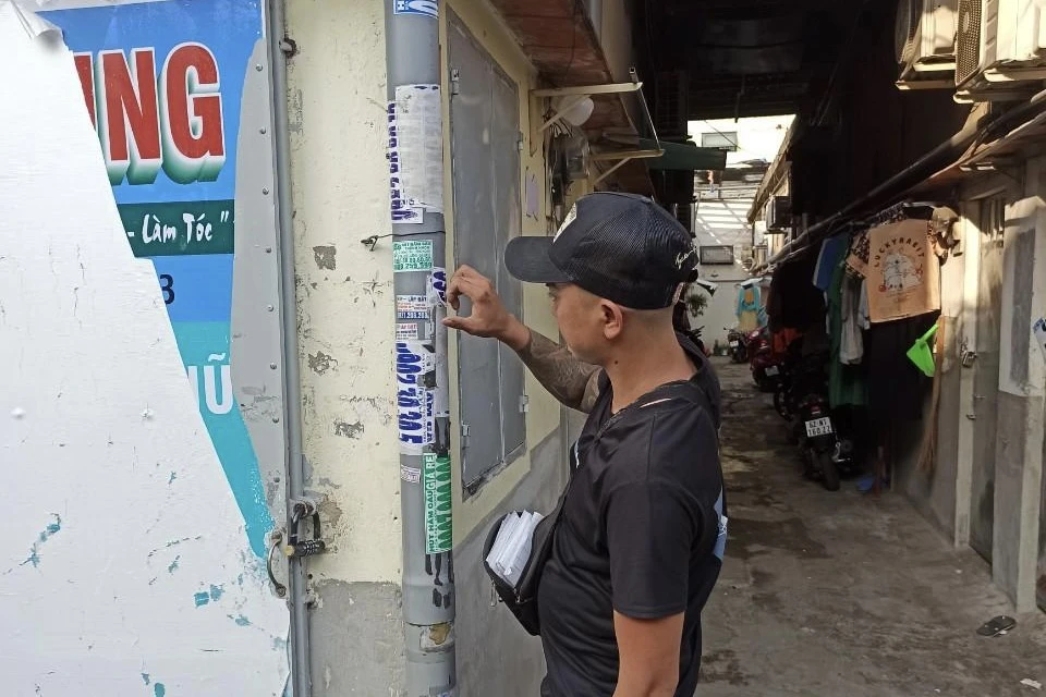 Hình ảnh đối tượng phải tự tay bóc gỡ những tờ quảng cáo mà mình đã dán trước đó. Ảnh: CACC