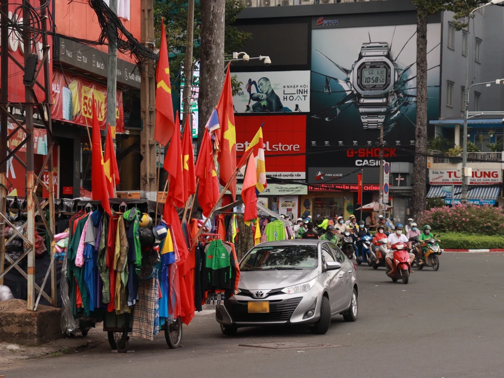Người dân cũng tranh thủ dịp lễ này bày bán cờ Đảng, cờ Tổ Quốc. Ảnh: TRẦN MINH