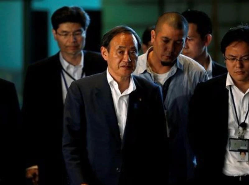 Chánh Văn phòng nội các Yoshihide Suga (giữa) trên đường đến họp với Thủ tướng Shinzo Abe hồi tháng 7. 