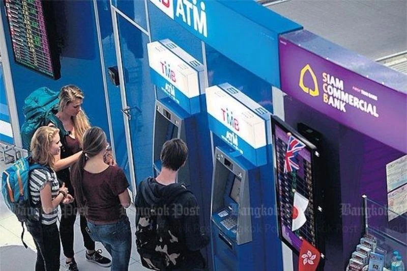Du khách rút tiền từ trụ ATM ở Bangkok (Thái Lan). 