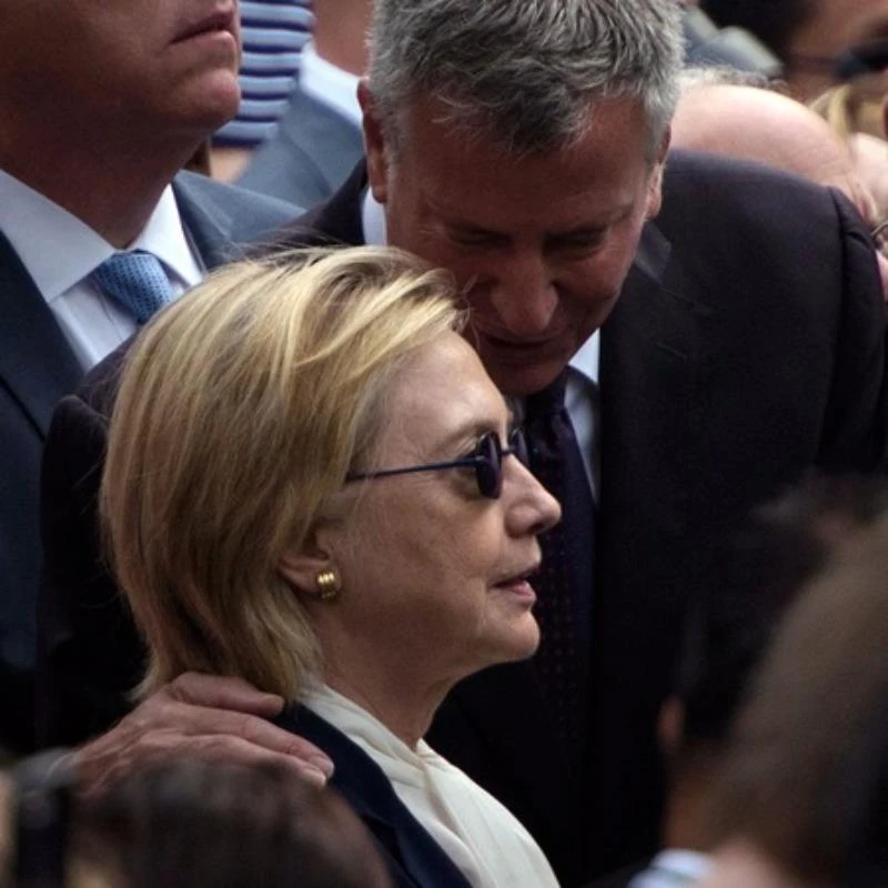 Bà Clinton được hộ tống rời buổi lễ ngày 11-9.