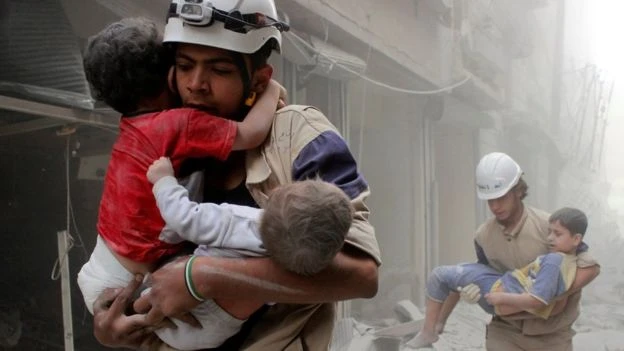 Nhân viên tổ chức White Helmets cứu người sau một trận không kích ở đông Aleppo (Syria).