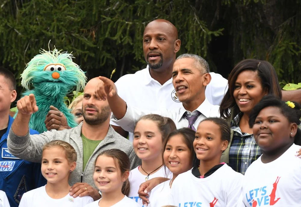 Vợ chồng Tổng thống Obama chụp hình chung với cầu thủ bóng rổ giải nghệ Alonzo Mourning (trên cùng), phi hành gia Sam Kass (trái), các diễn viên Seseme Street. 