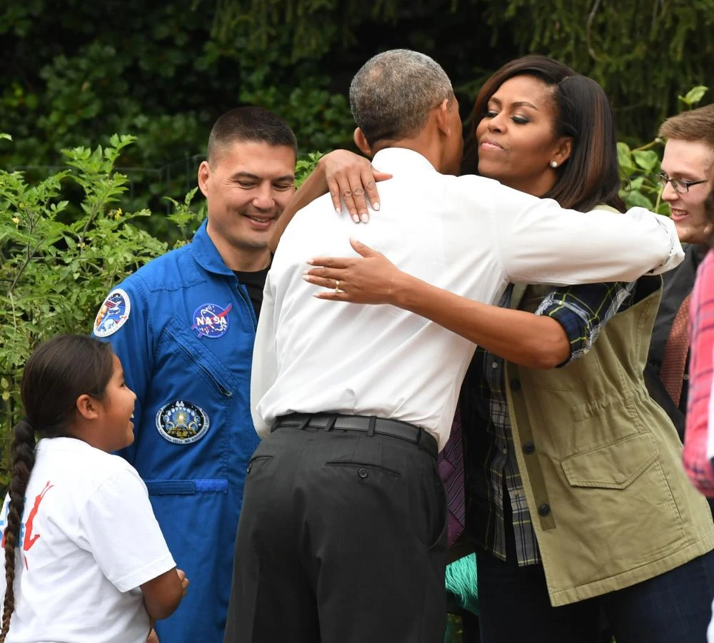 Tổng thống Obama ôm chào vợ khi bất ngờ đến thăm buổi thu hoạch. 