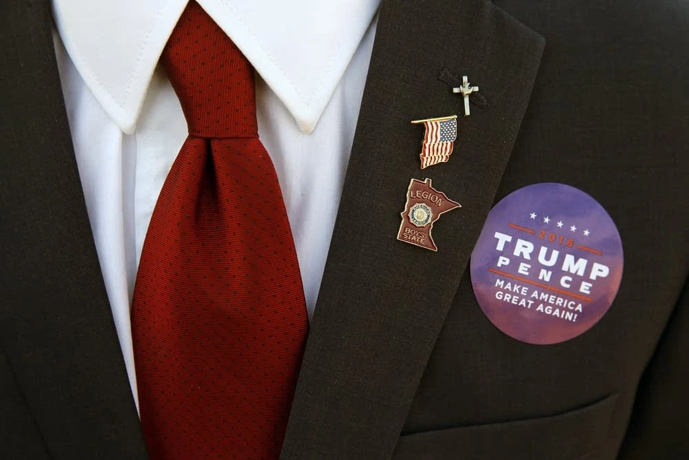 Một người ủng hộ ông Trump ăn mặc chỉnh tề xếp hàng chờ vào tham gia buổi vận động cuối cùng của Trump ngày 6-11. 