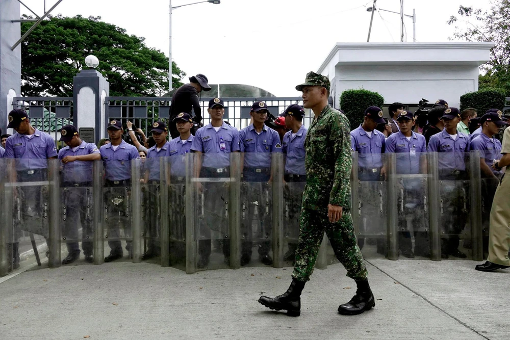 Hàng rào cảnh sát canh giữ ngoài cổng nghĩa trang anh hùng dân tộc Philippines trong lúc diễn ra lễ mai táng di hài ông Marcos ngày 18-11. 