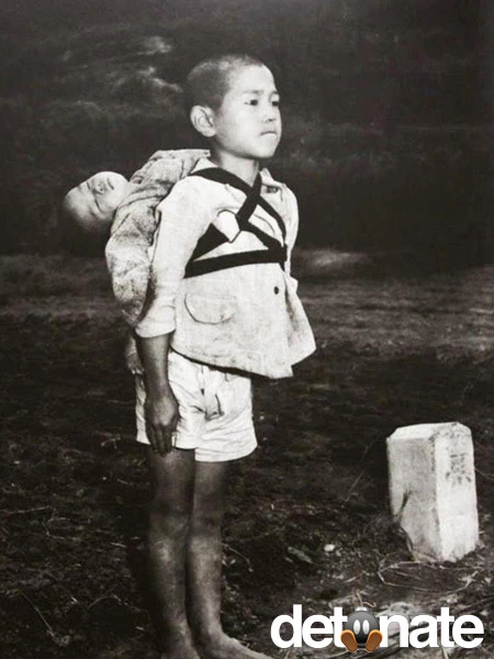 Một câu bé địu em trai đã chết của mình đến nơi hỏa táng. Bức ảnh được chụp năm 1945. 