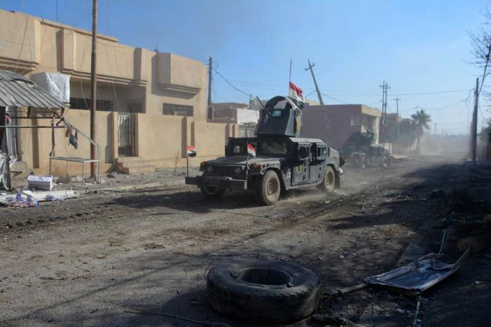 Xe quân sự Iraq trong một trận chiến với IS ở Mosul (Iraq) ngày 4-12. Ảnh: REUTERS