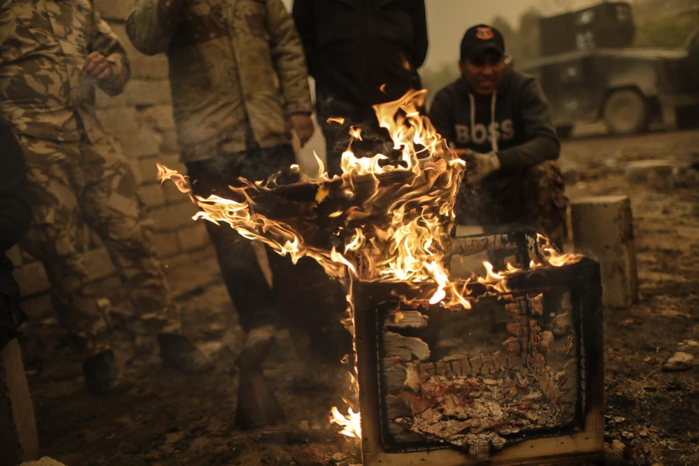 Lính Iraq đốt lửa sưởi ấm ở làng Gogjali ở Mosul (Iraq). 