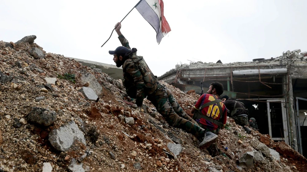 Quân chính phủ Syria cắm cờ quốc gia trên vùng đất đông Aleppo vừa chiếm lại từ phe nổi dậy ngày 5-10. Ảnh: AP 