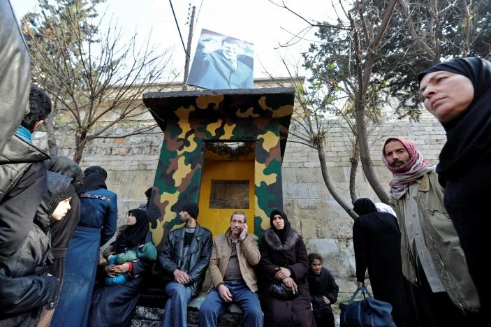 Người dân Aleppo đợi trước một trung tâm cảnh sát Syria để thăm người thân mới các khu vực phe nổi dậy kiểm soát ở đông Aleppo sơ tán sang, ngày 11-12. Ảnh: REUTERS 