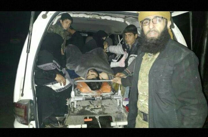 Tay súng nổi dậy và dân thường bị thương được đưa lên xe rời Aleppo. Ảnh: AMN