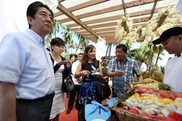 Vợ chồng Tổng thống Duterte (phải) và vợ chồng Thủ tướng Abe (trái) ăn sầu riêng trong một sự kiện tại Davao (Philippines) ngày 13-1. Ảnh: REUTERS