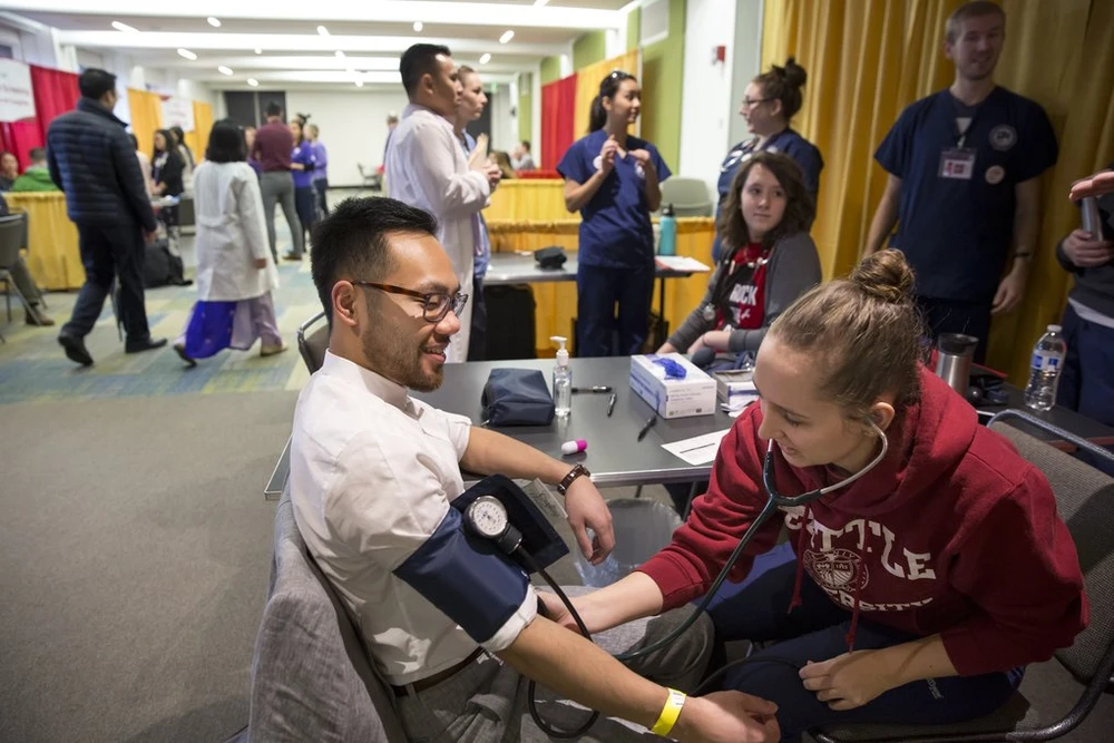 Jessie Saunders, học ngành y tá tại ĐH Seattle, đo huyết áp cho anh Jefferey Vũ. Ảnh: SEATTLE TIMES