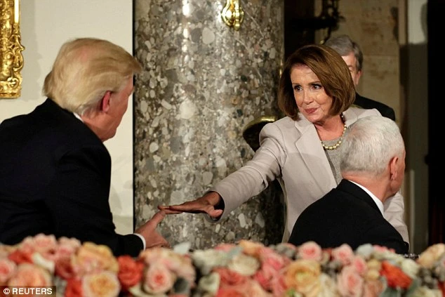 Lãnh đạo phe thiểu số Dân chủ tại Hạ viện Nancy Pelosi (phải) bắt tay Tổng thống Trump trong buổi tiệc trưa sau lễ nhậm chức của ông Trump ngày 20-1. Ảnh: REUTERS