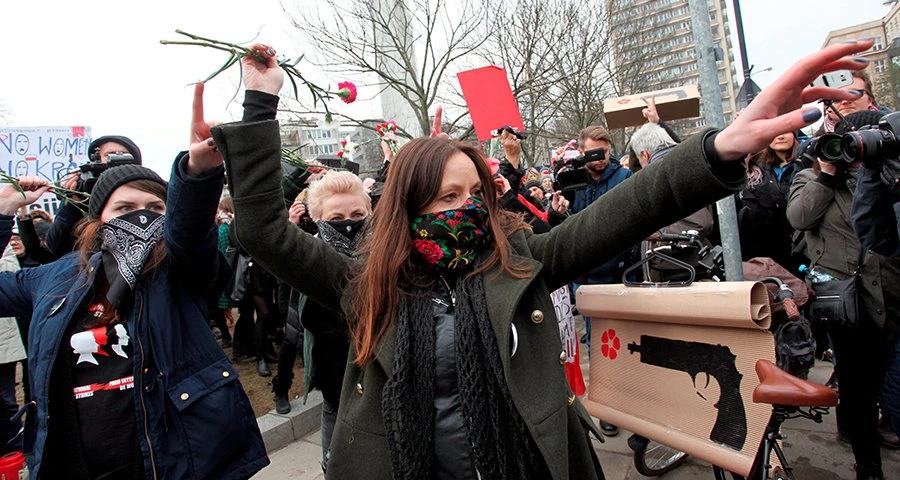Phụ nữ ném bỏ hoa trong cuộc tuần hành trước tòa nhà Quốc hội ở Warsaw (Ba Lan) ngày 8-3. Ảnh: REUTERS