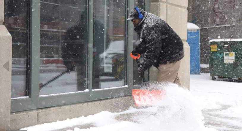 Dọn tuyết bên ngoài một cửa hàng ở Detroit (Michigan, Mỹ) ngày 13-3. Ảnh: AP