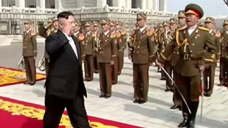Lãnh đạo Triều Tiên Kim Jong-un chào đội quân danh dự trước khi phát biểu khai mạc lễ diễu binh. Ảnh: ALJAZEERA