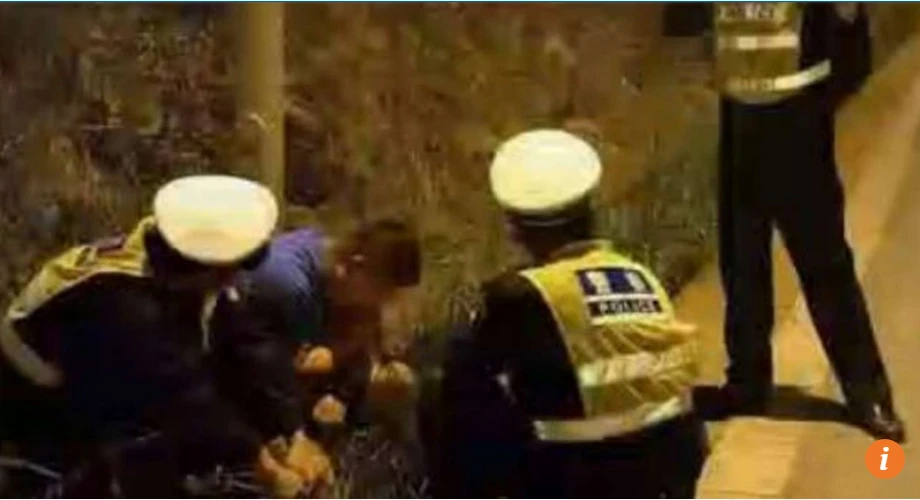 Tài xế say xỉn ngồi bứt cỏ ăn bên vệ đường. Ảnh SCMP chụp từ video