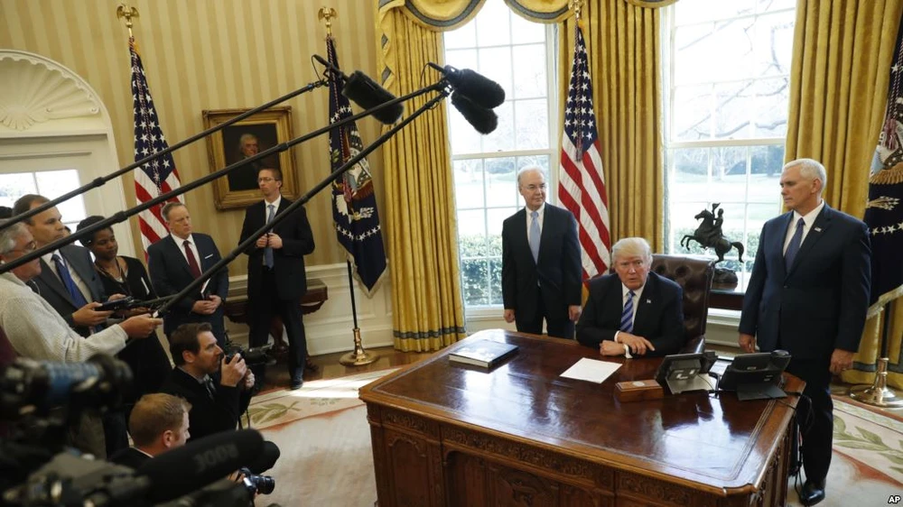 Ông Trump (ngồi) họp báo tại Nhà Trắng ngày 24-3 sau khi dự luật thay thế Obamacare của ông bị Hạ viện hủy bỏ phiếu. Ảnh: AP