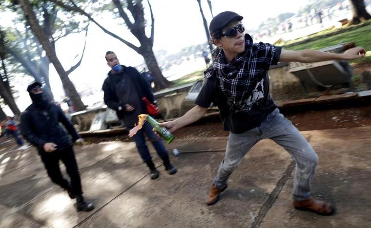 Người biểu tình ném chai lửa vào cảnh sát, ngày 24-5. Ảnh: REUTERS