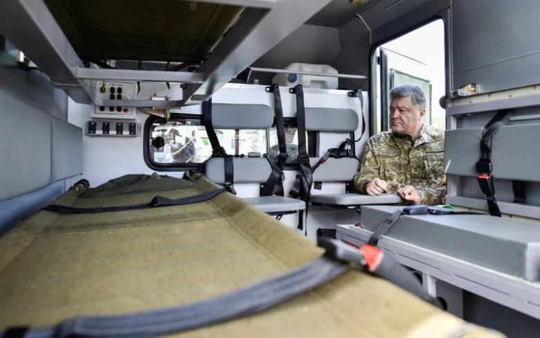 Tổng thống Ukraine Petro Poroshenko thăm một bệnh viện quân đội dã chiến tại vùng Donetsk (Ukraine) ngày 14-6. Ảnh: REUTERS